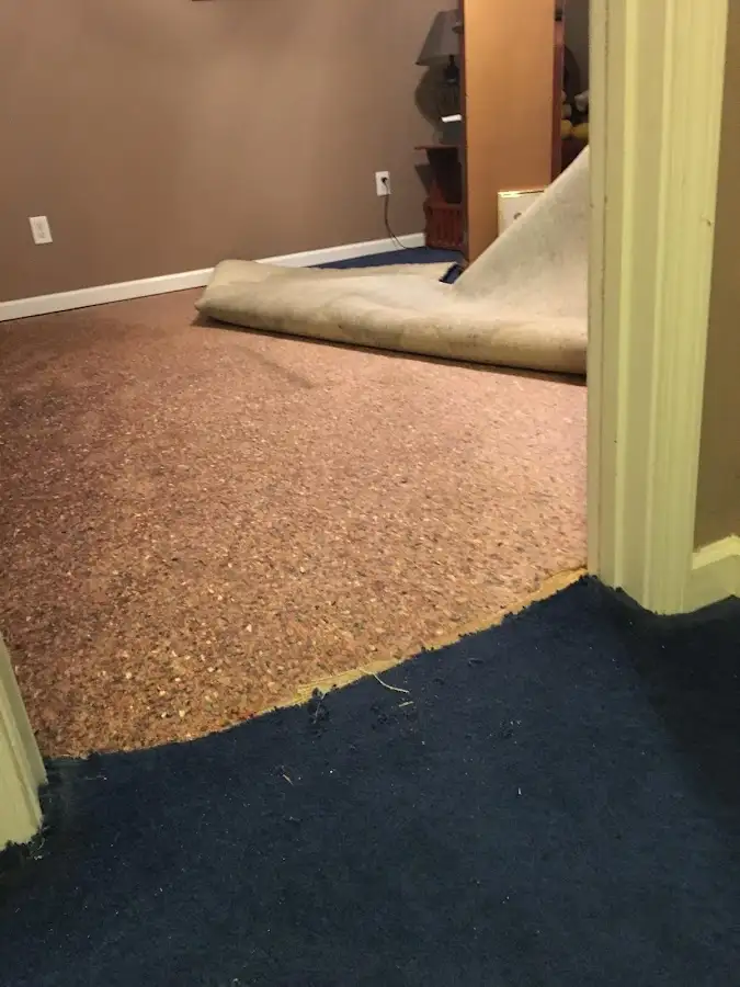 Carpet pad removal revealing water damage during Water Mitigation Services in Riverside